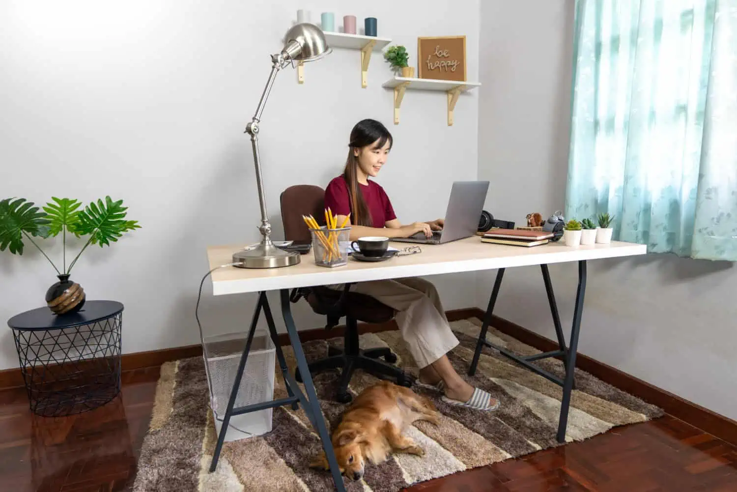 Frau im Homeoffice an höhenverstellbarem Schreibtisch mit ergonomischem Bürostuhl
